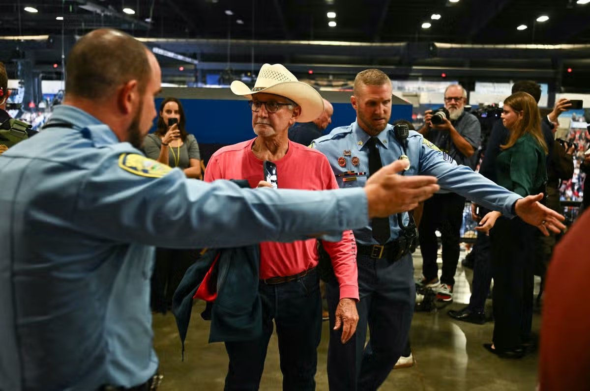 Un manifestante es escoltado fuera del mitin de campaña del presidente estadounidense Donald Trump.