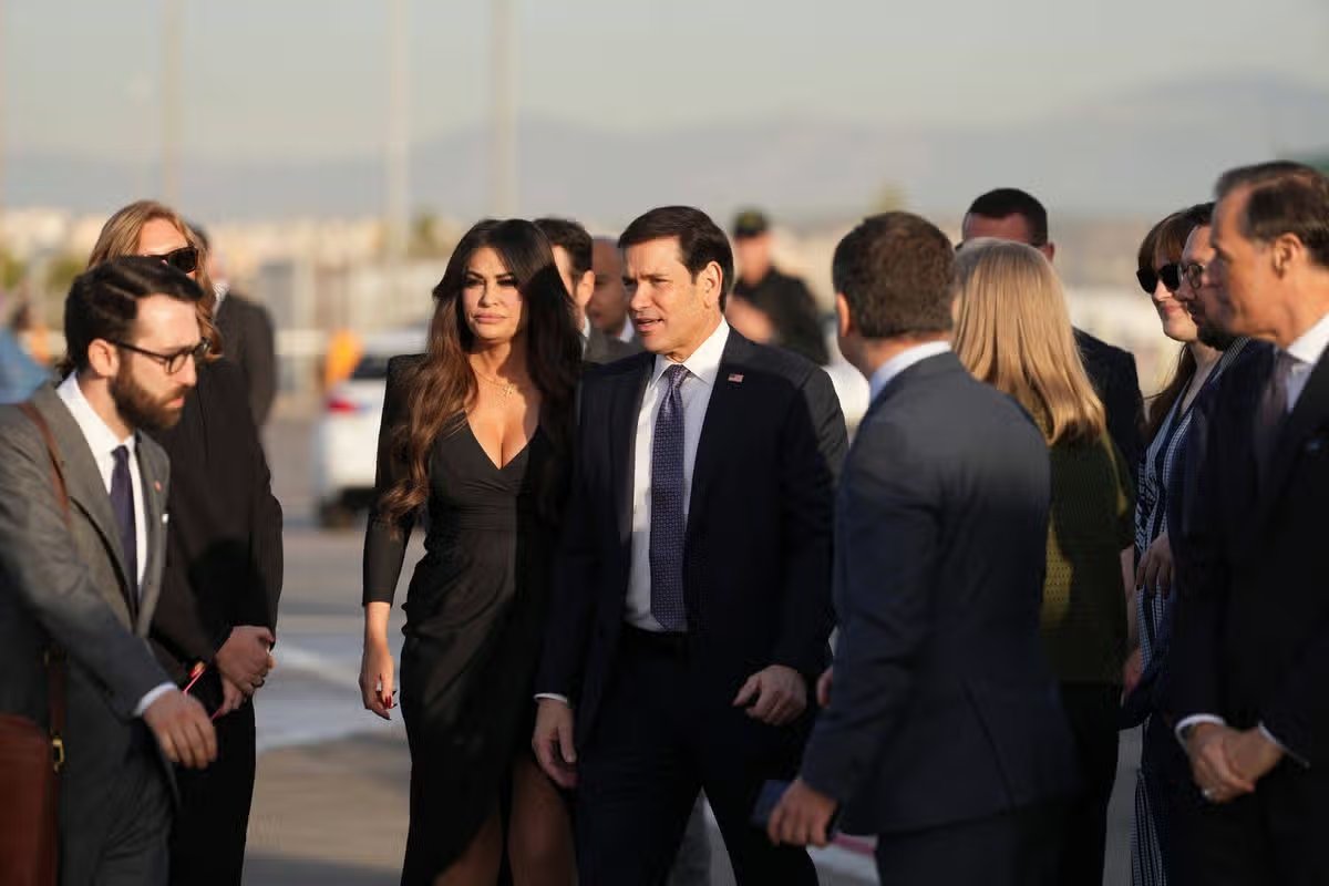 El secretario de Estado de Estados Unidos, Marco Rubio, al centro, y la embajadora de Estados Unidos en Grecia, Kimberly Guilfoyle, se encuentran en el Aeropuerto Internacional Eleftherios Venizelos, cerca de Atenas, Grecia, el jueves 8 de octubre de 2026, antes de que Rubio aborde un vuelo. (Foto AP/Mark Schiefelbein, Piscina)