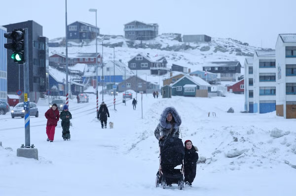 La gente camina sobre nieve fresca en el centro de la ciudad de Nuuk, Groenlandia, el 18 de enero de 2026.