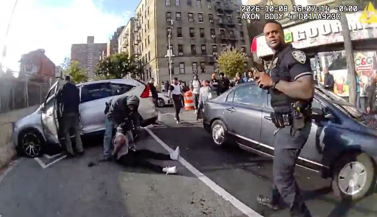 En este video de una cámara corporal usada por un oficial publicado por el Departamento de Policía de la ciudad de Nueva York (NYPD), agentes encargados de hacer cumplir la ley custodian a Oscar Belgal, un dominicano de 28 años que recibió un disparo de agentes federales de inmigración el jueves 8 de octubre de 2026 en Nueva York mientras conducía un automóvil con un niño de 5 años adentro.