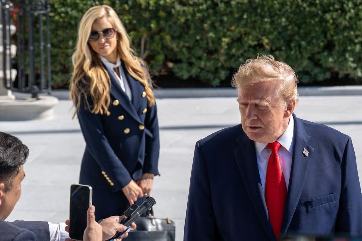La nueva secretaria de prensa de la Casa Blanca, Katie Zacharias, escucha al presidente Donald Trump hablar con los medios de comunicación antes de partir del jardín sur hacia Alaska el 13 de octubre de 2026.