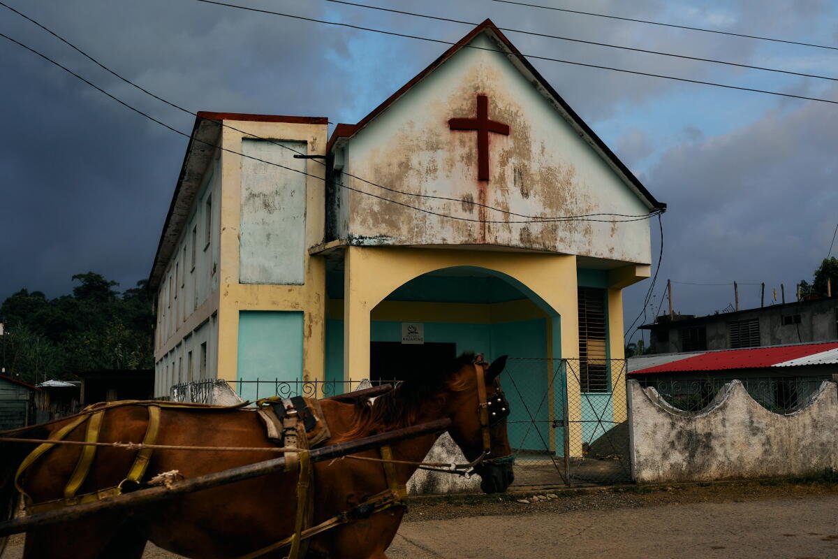 Un caballo tirando de un carro pasa frente a una iglesia en Baracoa, en el extremo oriental de Cuba.