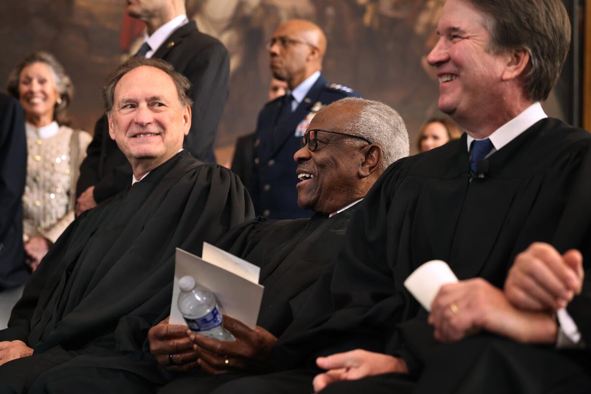 Los jueces asociados de la Corte Suprema Samuel Alito, Clarence Thomas y Brett Kavanaugh se ríen