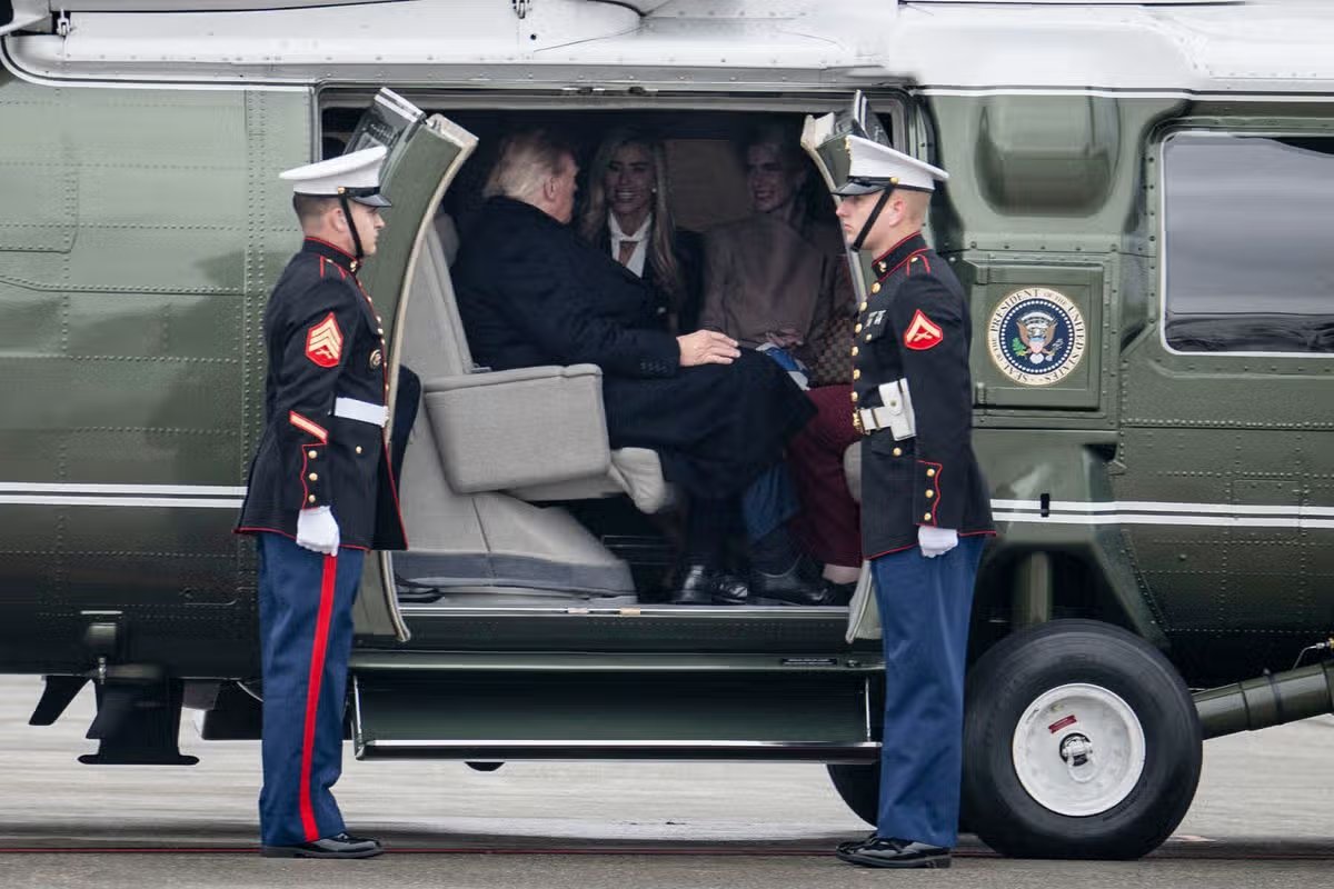 El presidente estadounidense Donald Trump habla con la secretaria de prensa de la Casa Blanca, Katie Zakaria, y su asistente Natalie Happ, después de abordar el Marine One.