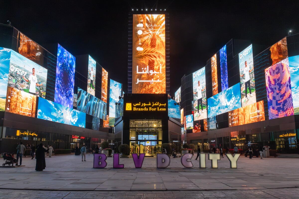 Pantallas gigantes iluminan el City Boulevard de la capital saudí.